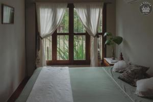 Un dormitorio con una cama grande con una ventana grande. en La casita de Mari, en Ruiz de Montoya