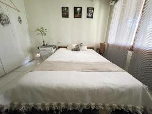 Un dormitorio con una gran cama blanca en una habitación. en La casita de Mari, en Ruiz de Montoya