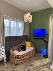 ein Wohnzimmer mit einem Korbsofa und einem Fernseher in der Unterkunft Tubajon Cliffside Villa in Laguindingan