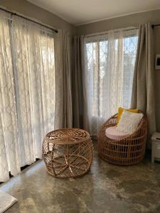 ein Wohnzimmer mit 2 Korbstühlen und Fenstern in der Unterkunft Tubajon Cliffside Villa in Laguindingan