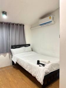 a small bedroom with a bed with a white sheets and aasser at Chubbi 5 Room10 in Bang O +3 photos