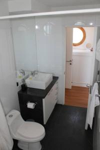 a bathroom with a white toilet and a sink at Exclusiva casa con vista panorámica al mar in Guanaqueros