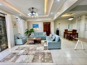 杉祖Zuri's Luxurious Oceanview Penthouse, Meters from the beach的客厅里有蓝色的沙发和一张桌子