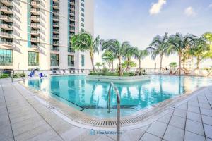 une grande piscine avec des palmiers en face d'un bâtiment dans l'établissement Apartment in New Luxury Condo in Downtown, à Miami