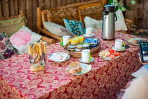 a table with a pink table cloth with food on it at Palm Tree Villa Nungwi in Nungwi