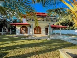 una casa con una palma di fronte di Solace Inn RESIDENCE - 5 Min Walk to Beach a Tangalle