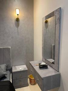 a bathroom with a dresser and a mirror on a wall at Villa Oasis in Karachi