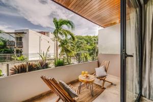 Una habitación con balcón con mesa y sillas. en Sunrise Studio with Fast-WIFI, Rooftop Pool, Spa, en Tulum