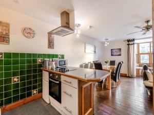 a kitchen with green tiles on the walls and a table at The Drovers Rest - Uk43567 in Haltwhistle