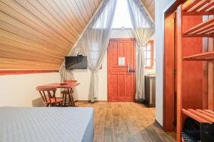 a bedroom with a bed and a table and a door at Sítio Terra Sertaneja - Chalé Estou Apaixonado in Turvo dos Góis