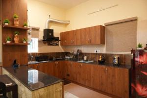 a large kitchen with wooden cabinets and black counter tops at The Great Escape at Yercaud in Yercaud