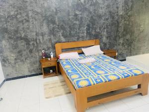 a bedroom with a bed and a nightstand with a bed sidx sidx at Senkeur in Sali Nianiaral +4 photos