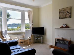 a living room with a couch and chairs and a television at Hamilton Terrace in Lamlash