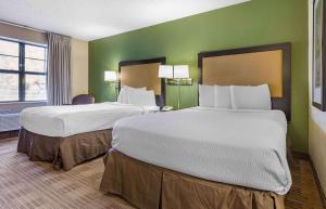 two beds in a hotel room with green walls at Extended Stay America Suites - Austin - Northwest Arboretum in Austin