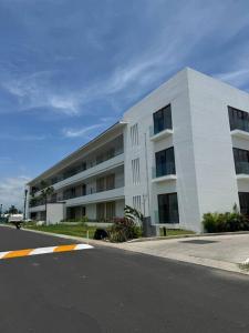 a large white building on the side of a street at Comfort at Club De Golf el Tigre in Nuevo Vallarta  +19 photos