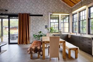a kitchen with a wooden table and a dog laying on the floor at The Loft House in Kaikoura
