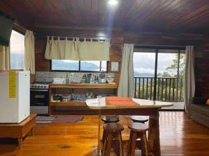 a kitchen with a table and two stools in a room at Cabina vista al valle Monteverde in Monteverde Costa Rica +47 photos