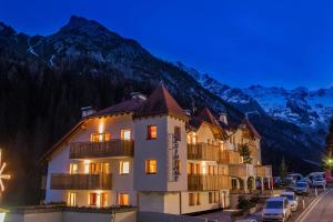 Un hotel con coches aparcados frente a una montaña. en Stelvio Residence, en Trafoi