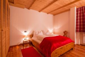 a bedroom with a bed with a red blanket at Stelvio Residence in Trafoi