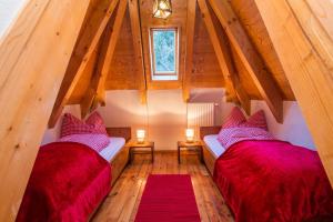 Duas camas num quarto no sótão com tectos em madeira em Stelvio Residence em Trafoi