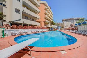 a swimming pool with a bench next to a building at Hotel Rosalba - Valentini Family Village in Bellaria-Igea Marina