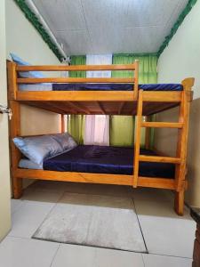 a couple of bunk beds in a room at Ina Puring's House in Itogon