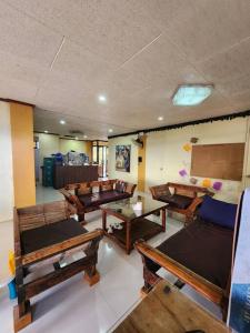 a room with many wooden benches and tables at Ina Puring's House in Itogon