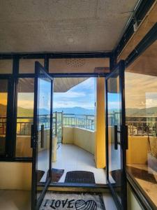 an open door to a balcony with a view of the ocean at Ina Puring's House in Itogon