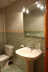 ein Badezimmer mit einem Waschbecken, einem WC und einem Spiegel in der Unterkunft Piscina Mar 1 in Sant Carles de la Ràpita