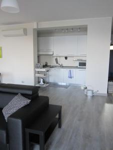 a living room with a black couch and a kitchen at Appartamento alle Rive in Salò