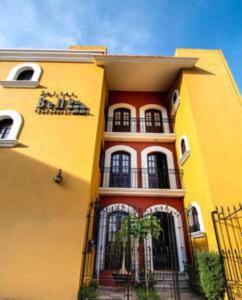 ein gelbes Gebäude mit einer Palme davor in der Unterkunft Depa Kala in Oaxaca de Juárez