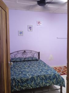 a bedroom with a bed with a blue comforter at ZR Homestay Kemaman with 3 Bedroom 2 Bathroom - 2 Room AC 1 Room Fan - Not Sharing House in Cukai