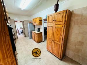 Una cocina con gabinetes de madera y refrigerador. en Mantombi's Guest House, en Graskop