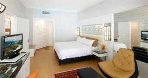 a room with a bed and a tv and a couch at Holiday Villa Resort & Beachclub Langkawi in Pantai Cenang