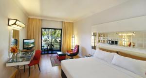 a hotel room with a bed and a table and chairs at Holiday Villa Resort & Beachclub Langkawi in Pantai Cenang