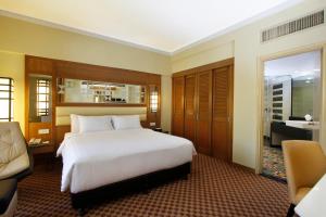 a bedroom with a large white bed and a bathroom at Holiday Villa Resort & Beachclub Langkawi in Pantai Cenang