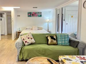 a living room with a bed and a green couch at Zen Escape Guest House " Location 1" - Three listings - Romantic Escape, Cozy Delight, Oasis Suite in Brisbane