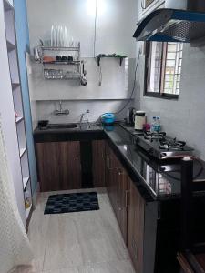 a small kitchen with a sink and a stove at Urban green Studio Apartment in Jorhāt +1 photo