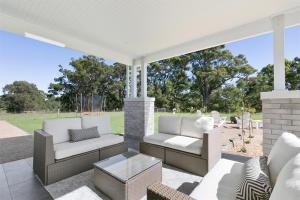 a patio with two couches and a table at Black Swan Retreat in Metung +22 photos