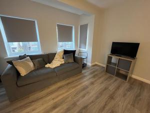 グリーンフォードにあるComfortable 2 bedroom, 1 bathroom, West London flatのソファと薄型テレビのあるリビングルーム