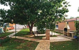 a park with a bench and a tree and a building at Holiday Apartment Privlaka 06 in Privlaka