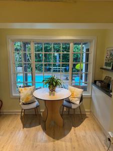 a table and chairs in a room with a window at Rose Thatch Cottage in Howick