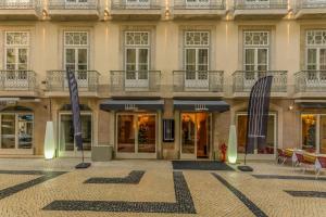 un edificio con dos sombrillas azules en un patio en behotelisboa, en Lisboa