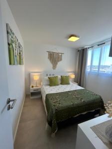 a bedroom with a bed with green sheets and pillows at Apartamento céntrico con garage in Mercedes