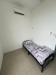 a small bed in a room with a white wall at Hostel TTDI in Shah Alam