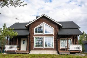 a house with two white benches in front of it at Koskikara in Äkäslompolo