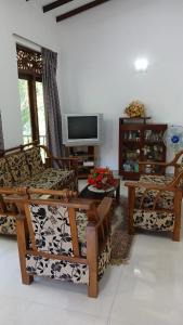 Una sala de estar con dos sillas y un televisor. en Ranawana Freedom Lodge, en Katugastota