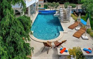 a swimming pool with chairs and a water slide at Nice Home In Trogir With House Sea View in Trogir