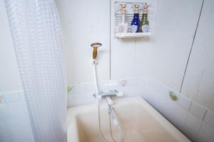 a white bathroom with a shower and a tub at FamB in Nakafurano