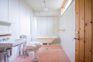 a bathroom with a toilet and a sink and a tub at FamB in Nakafurano